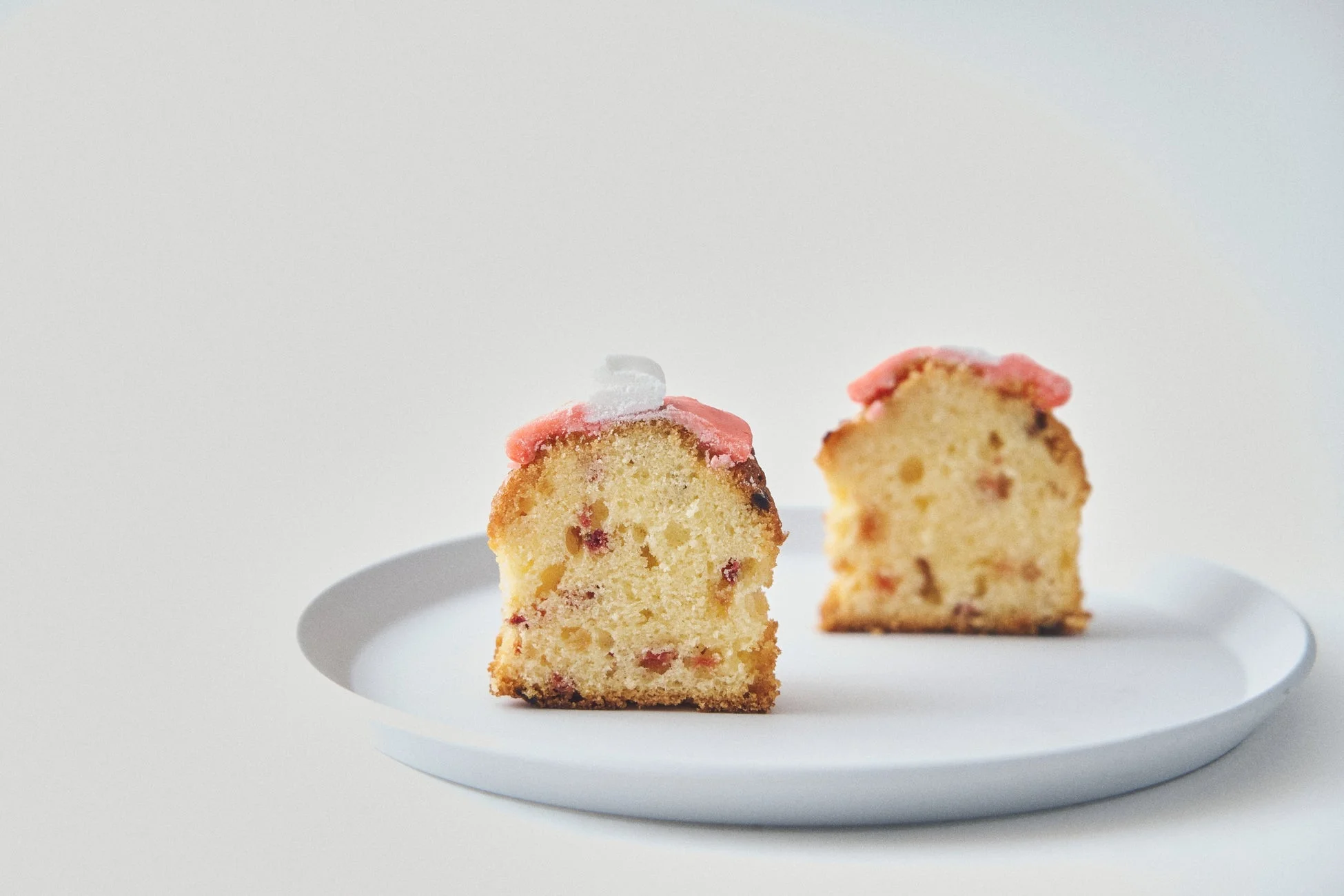 ピンクと白のアイシングが飾られた2切れのパウンドケーキ