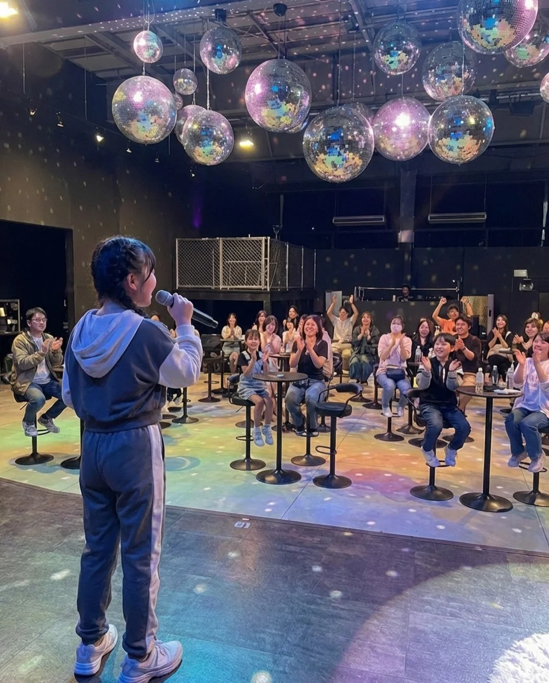 歌唱中の人物と観客の様子