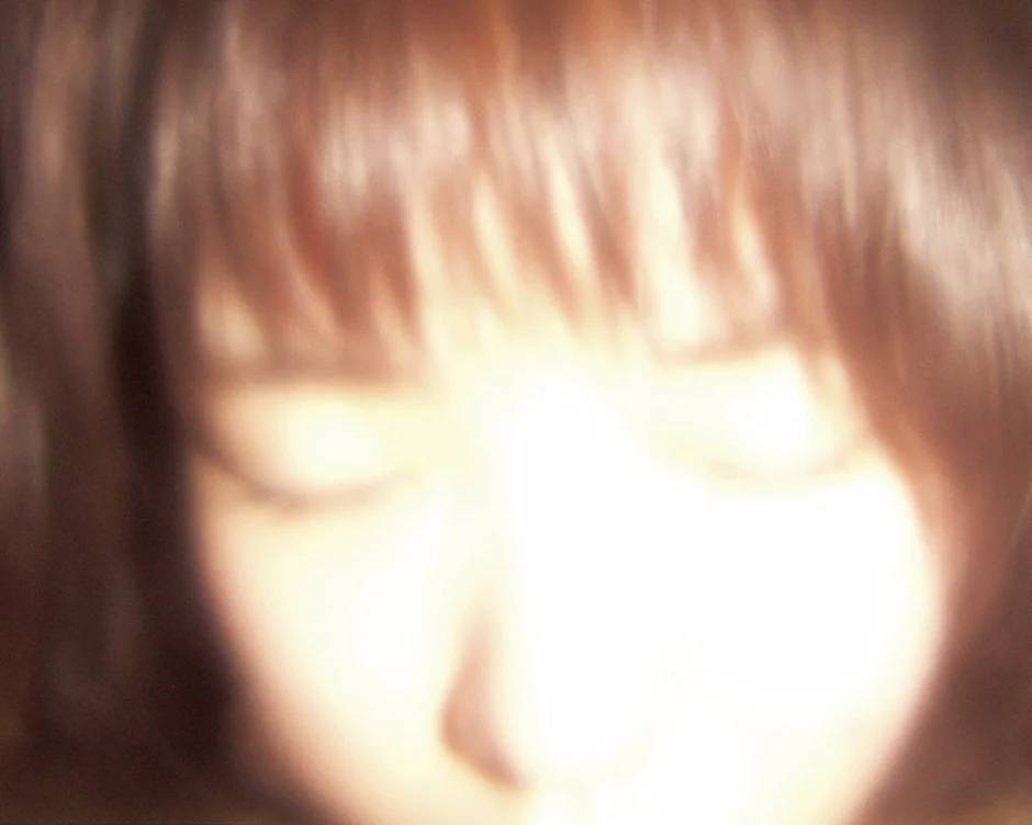 光で白飛びし、ぼかされた女性の顔のクローズアップ