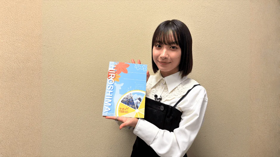 藤﨑ゆみあさんが「HIROSHIMA」と書かれた水色のノートブックを持っている様子