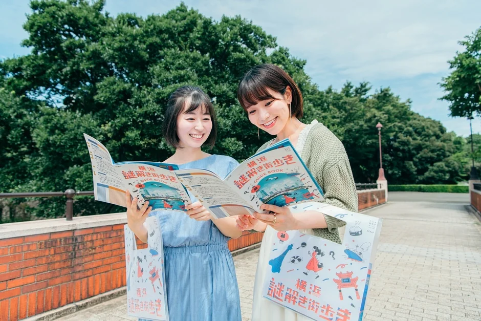 横浜謎解き街歩きのガイドブックを見る女性たち