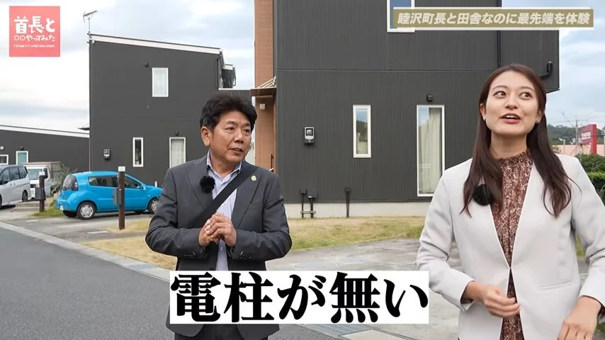 睦沢町長と女性が、電柱のない住宅街を視察している様子。