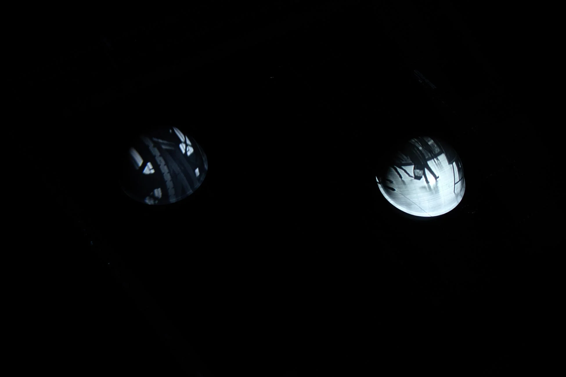 真っ黒な背景に、光を反射する二つの水滴のような円形が浮かんでいます。