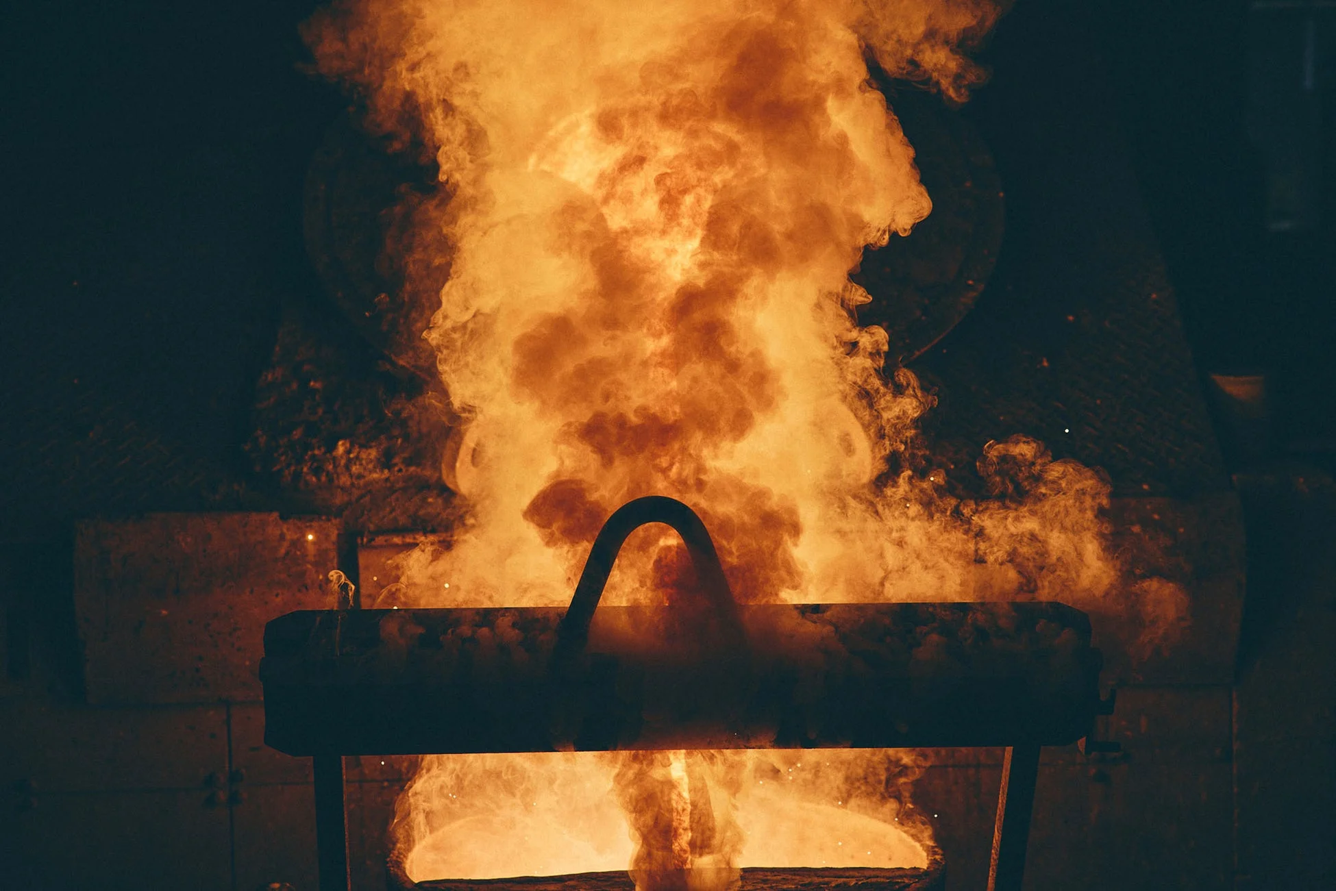 溶融金属から立ち上る炎と煙