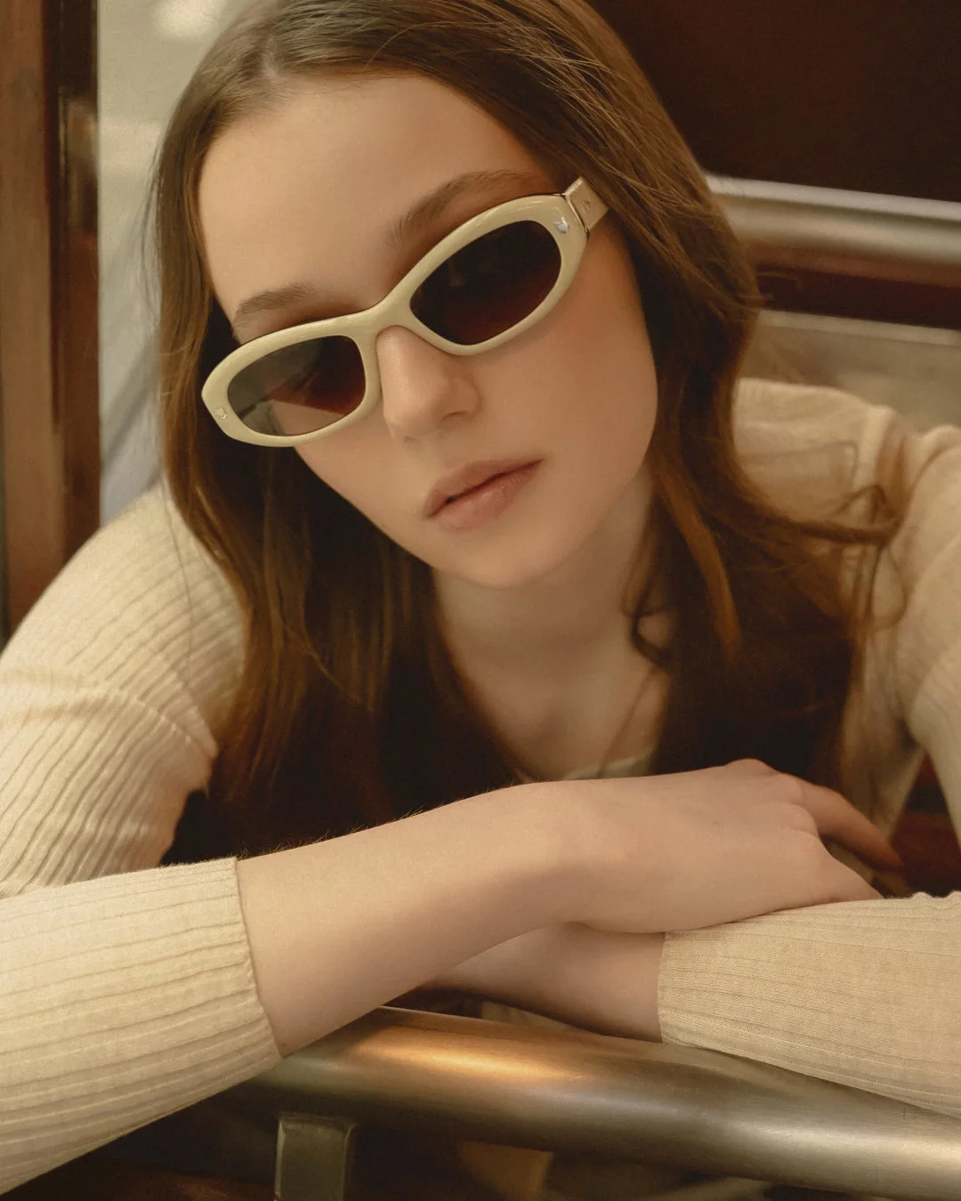 ベージュのサングラスとリブ編みトップスを着用した若い女性のポートレート