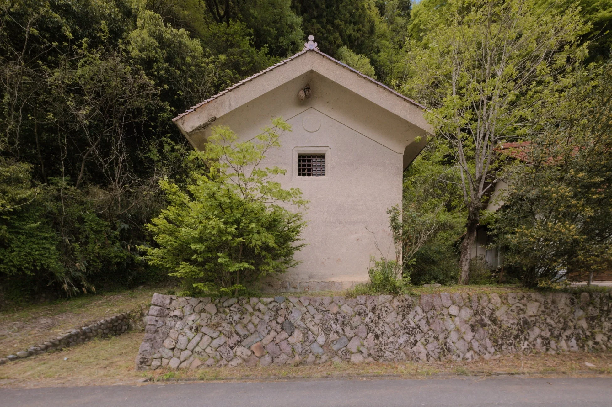 のどかな田舎の風景に立つ白い壁の小さな建物