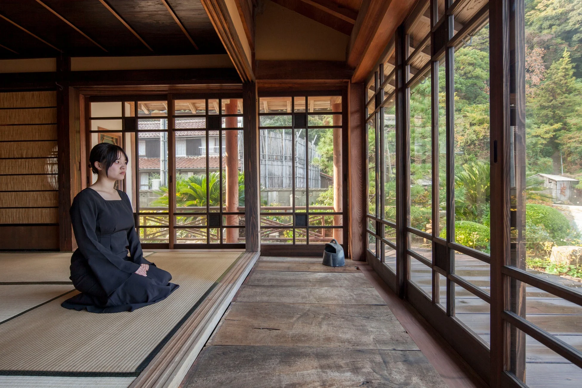 和室で畳に座り庭園を眺める女性