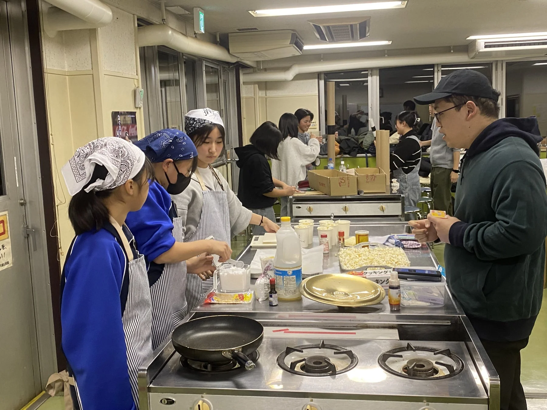 調理実習をする学生と大人