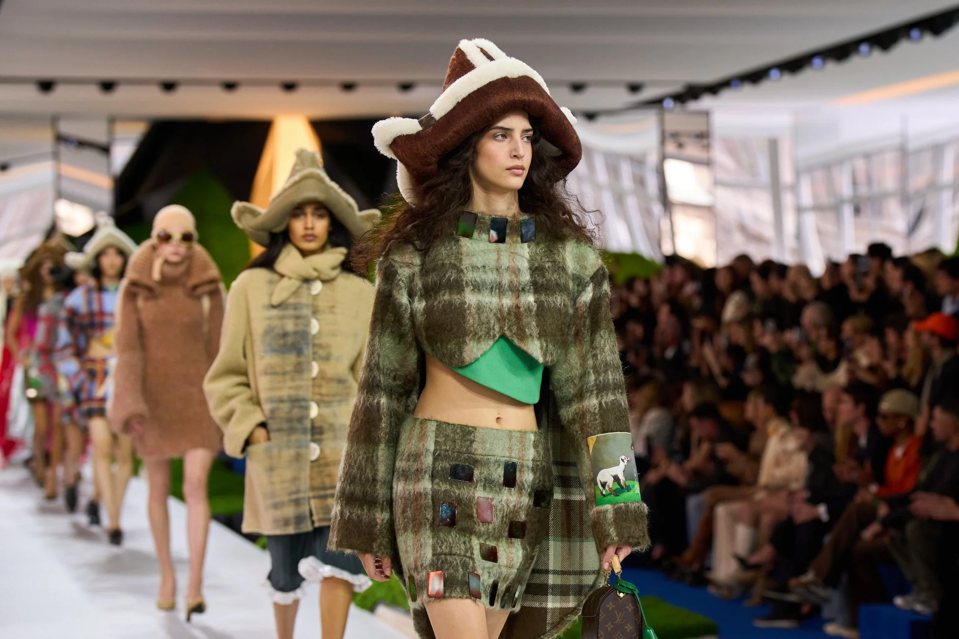 特徴的な帽子とチェック柄のコートを着用したモデル