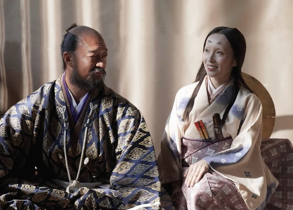 和装の男女が座って見つめ合う