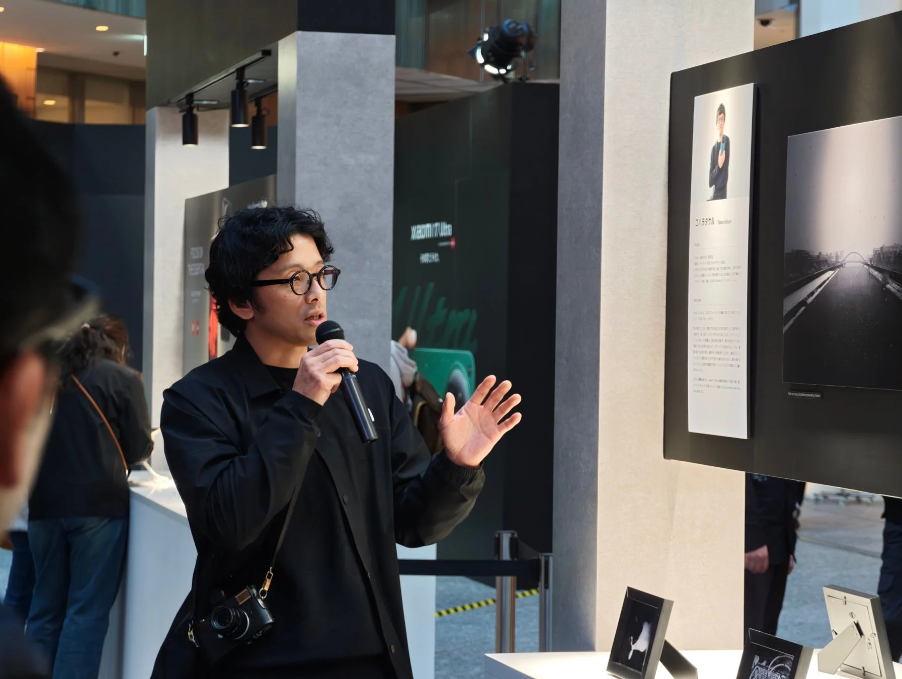 眼鏡をかけた男性がマイクを持って講演している様子