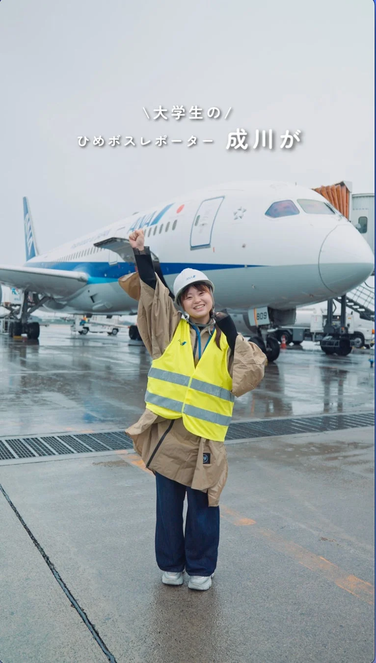 空港でガッツポーズをする大学生レポーター