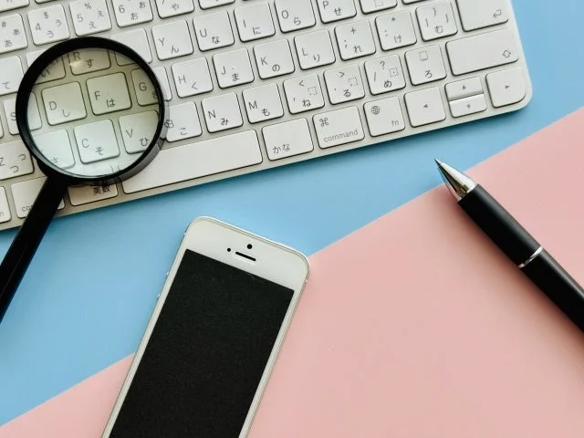 デスクに置かれたキーボードと虫眼鏡