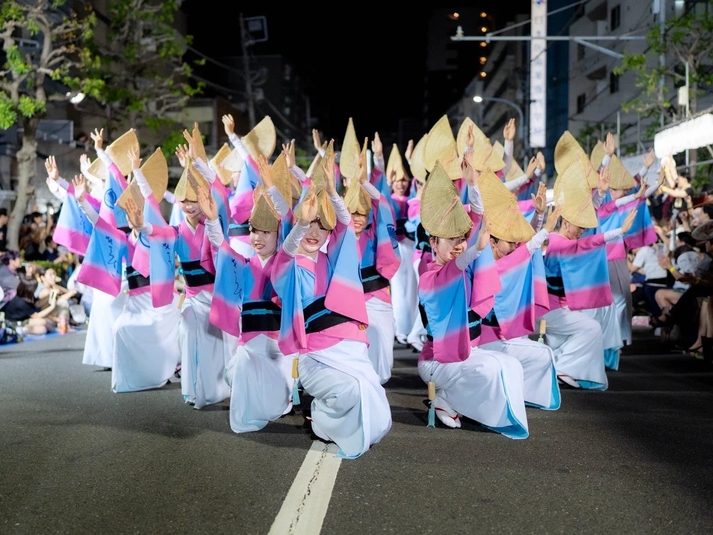 夜の街中で阿波踊りを披露する女性たち