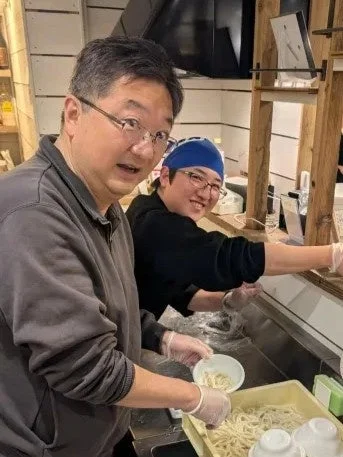 うどんをよそっている男性たち