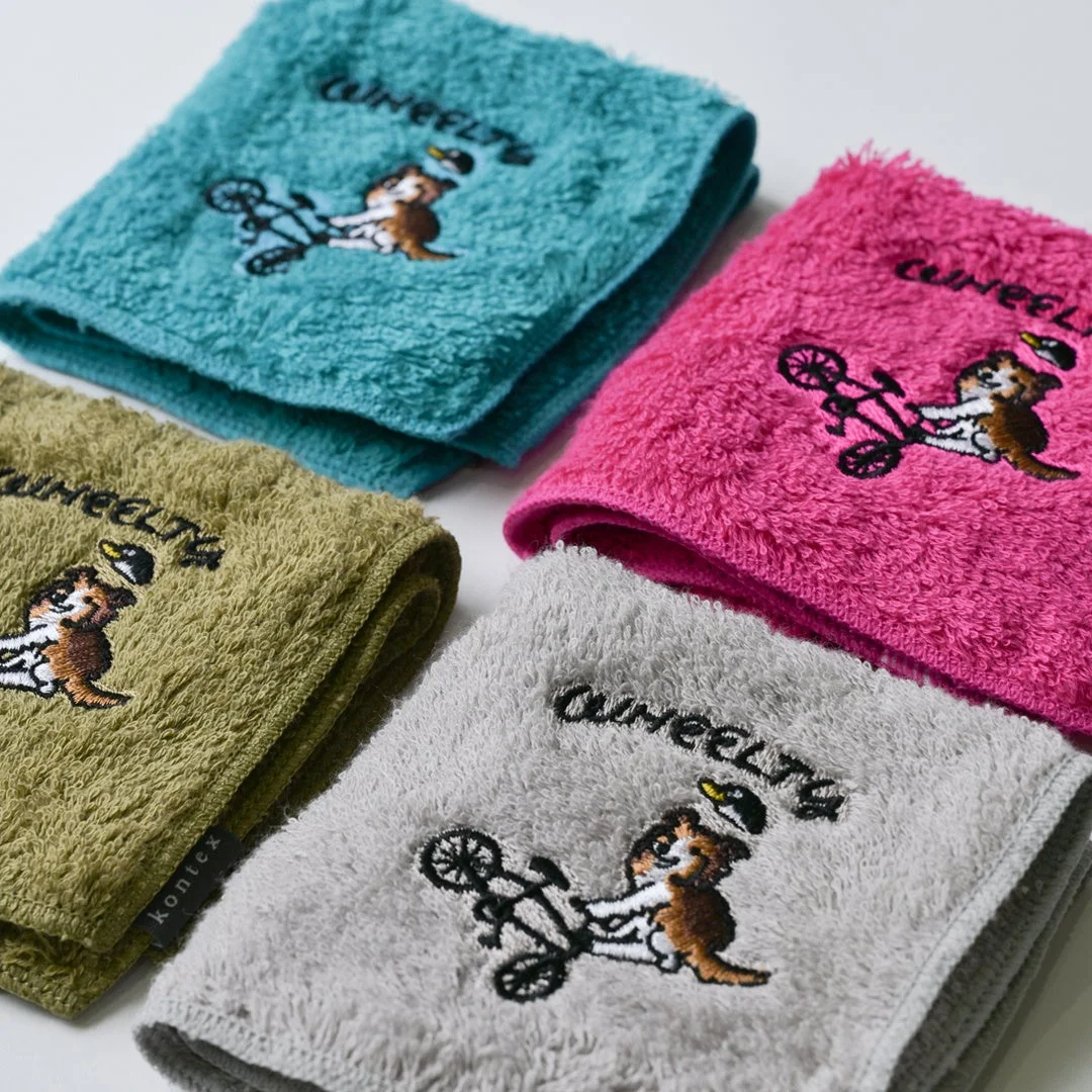 犬が自転車に乗ったデザインのカラフルなハンドタオル