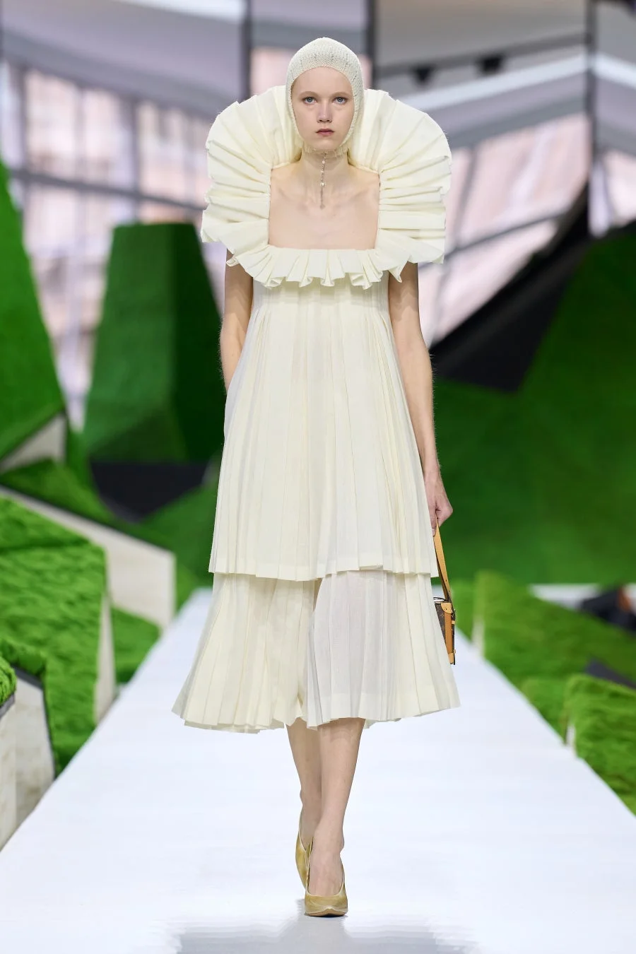 クリーム色の個性的なドレスを着用したモデル