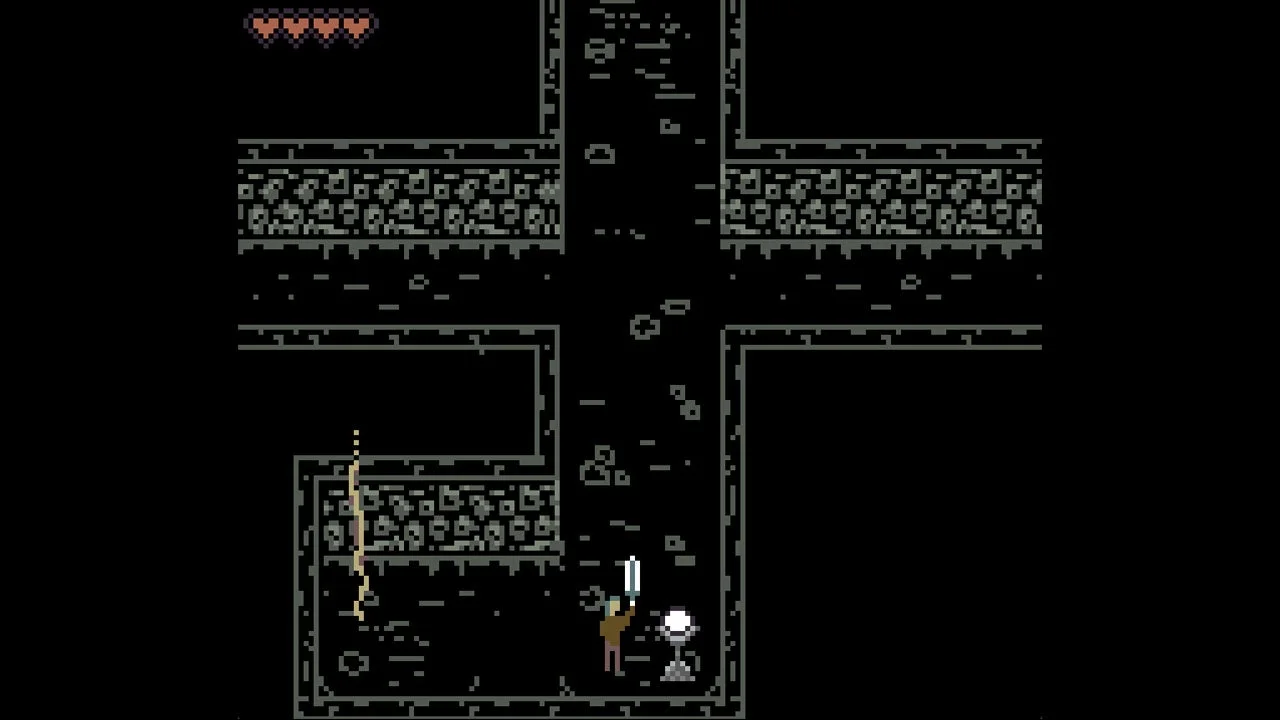 ピクセルアートで描かれたレトロなゲーム画面。プレイヤーキャラクターが剣を持ち、暗いダンジョンらしき場所を探索している様子。画面上部にはライフゲージとして赤いハートが5つ表示されています。