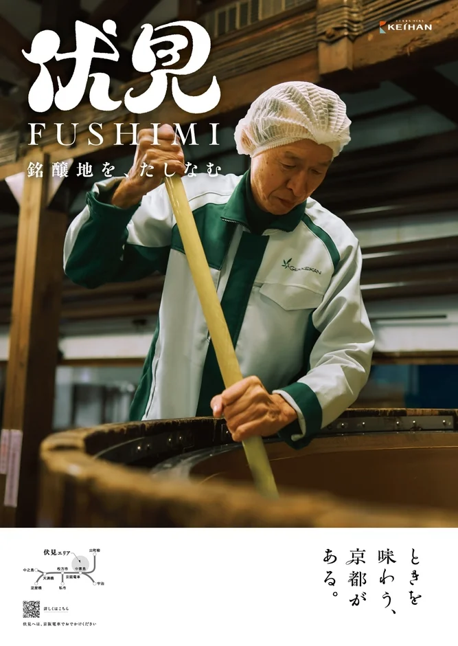 京都伏見の酒蔵で働く職人が、日本酒の仕込みを行う様子を写した京阪電車の広告。伏見の銘醸地としての魅力を伝え、京阪電車での訪問を促している。