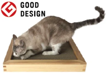 グッドデザイン賞のロゴと爪とぎで遊ぶ猫