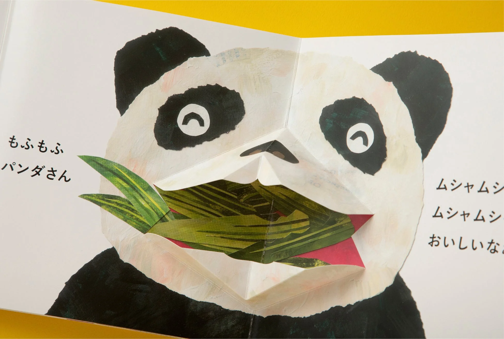 ポップアップ式の絵本が開かれ、笹の葉を食べるパンダが描かれている