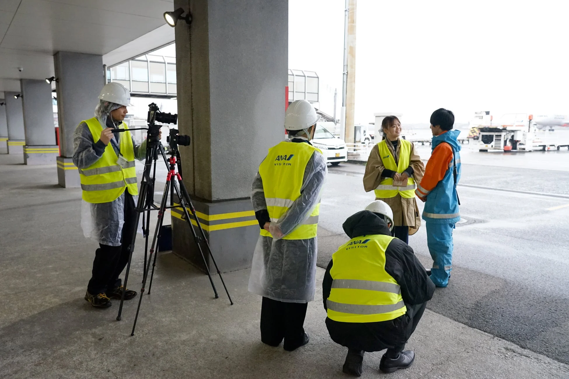 空港で活動する撮影チームとANAの作業員