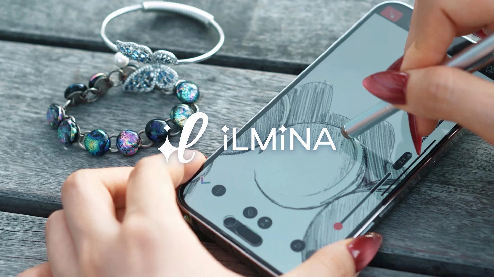 スマートフォンにスタイラスペンで描画する手元とブレスレット