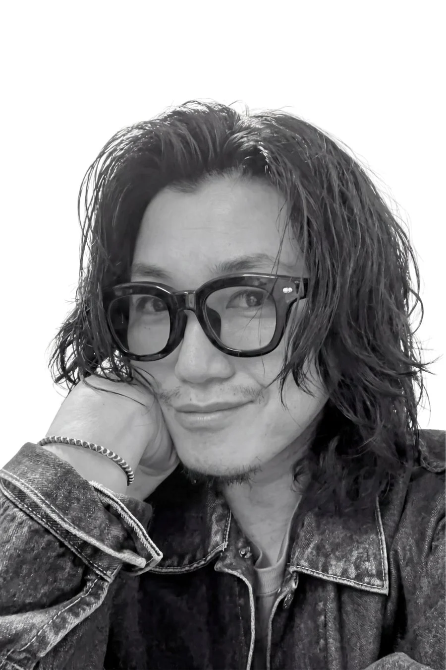 メガネをかけた長髪の男性の白黒ポートレート