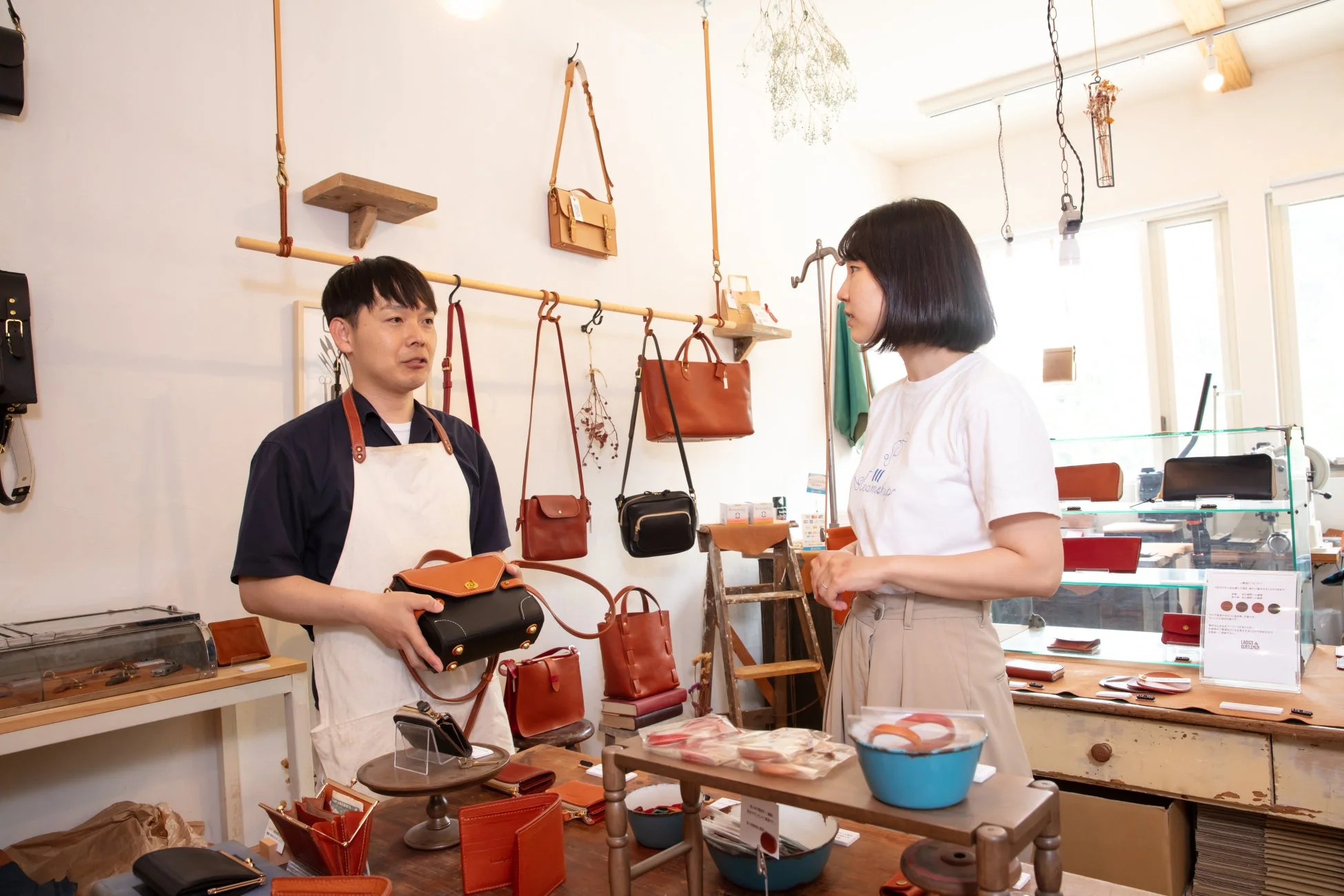 革製品の専門店で商品について説明する店員と顧客