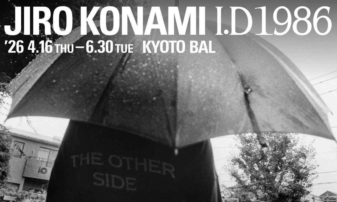 雨が降る中、傘をさした人物の後ろ姿を捉えた白黒写真