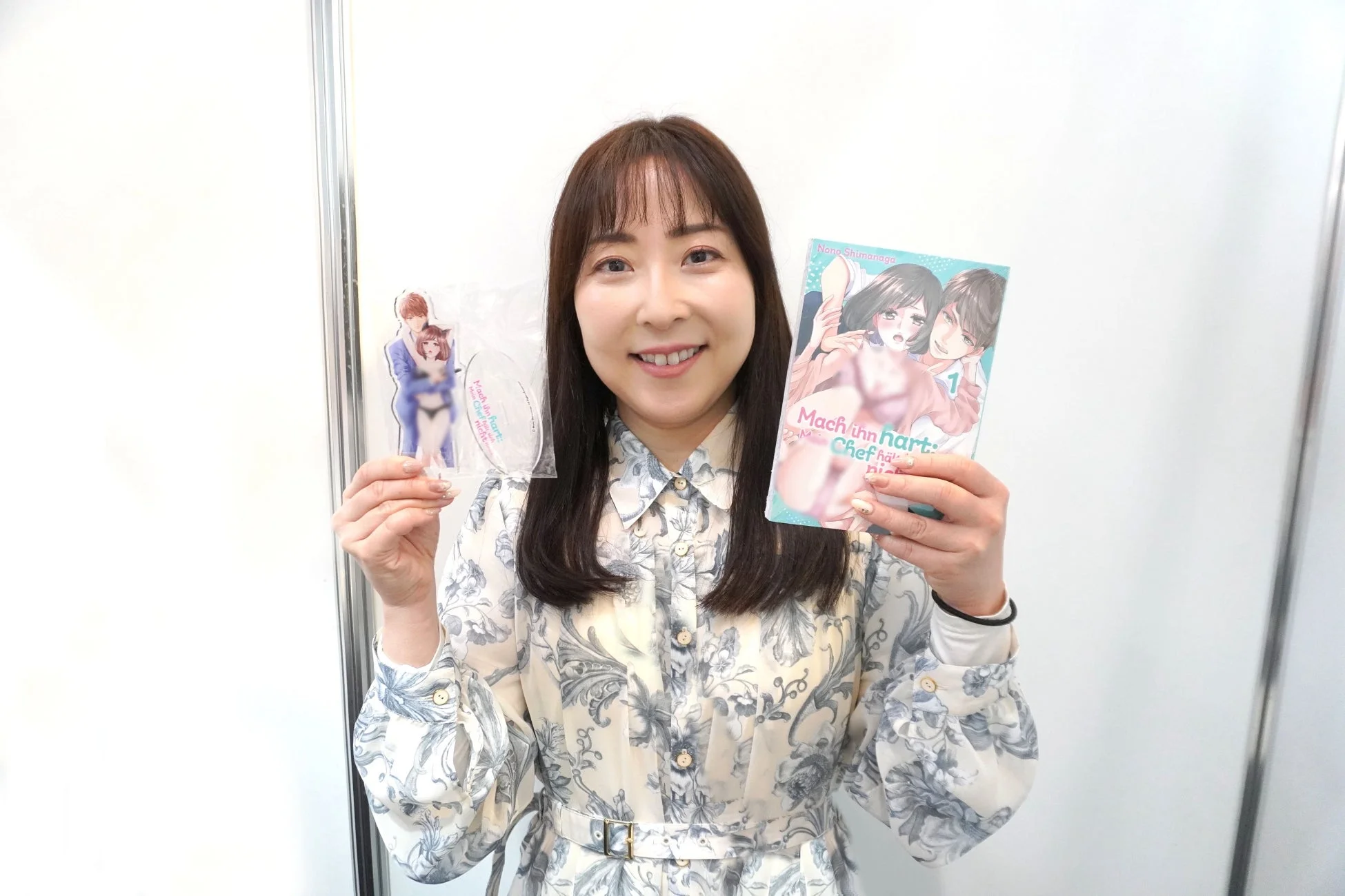笑顔で作品を持つ漫画家・嶋永のの氏