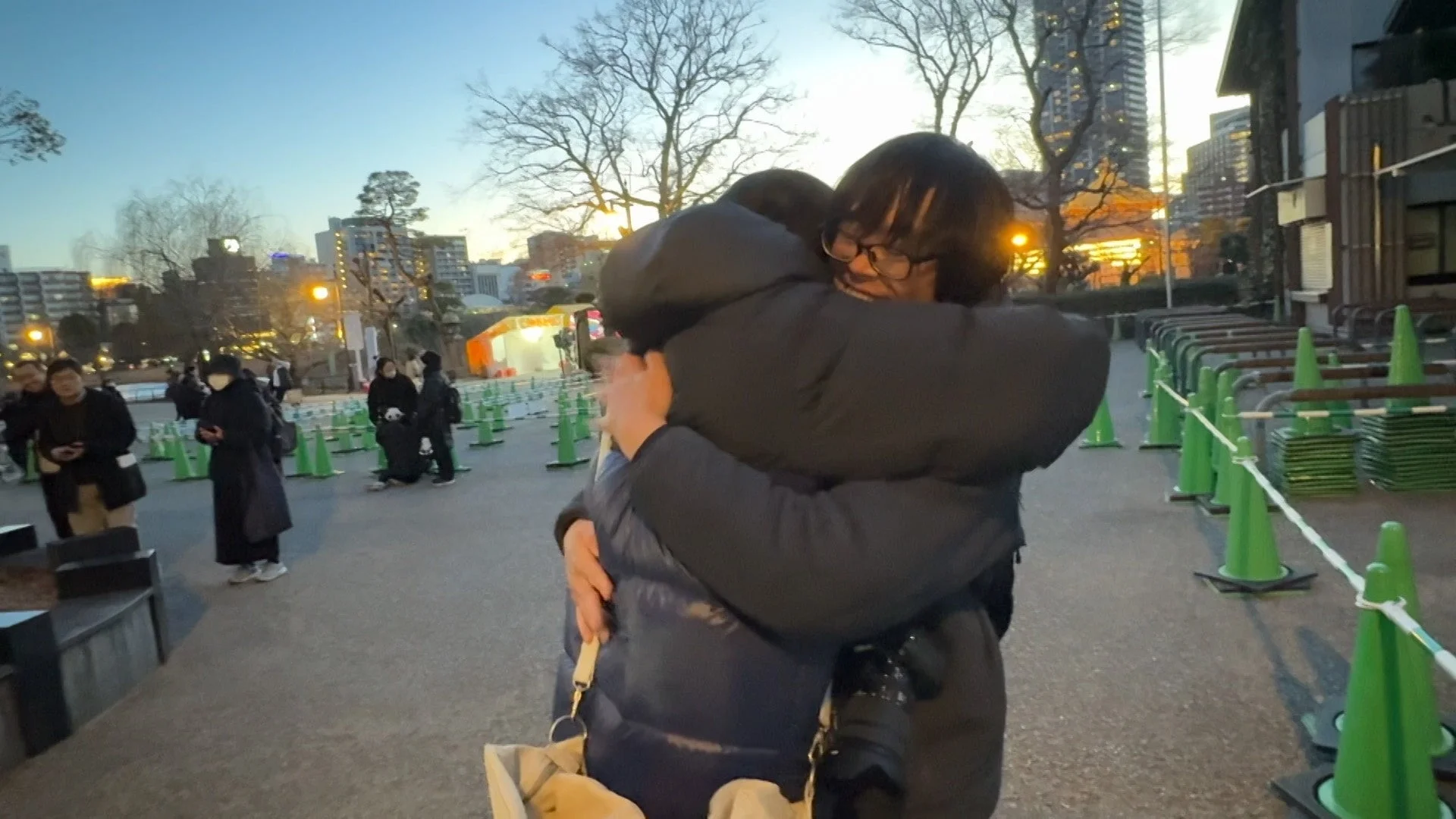 夕暮れの屋外で抱き合う二人