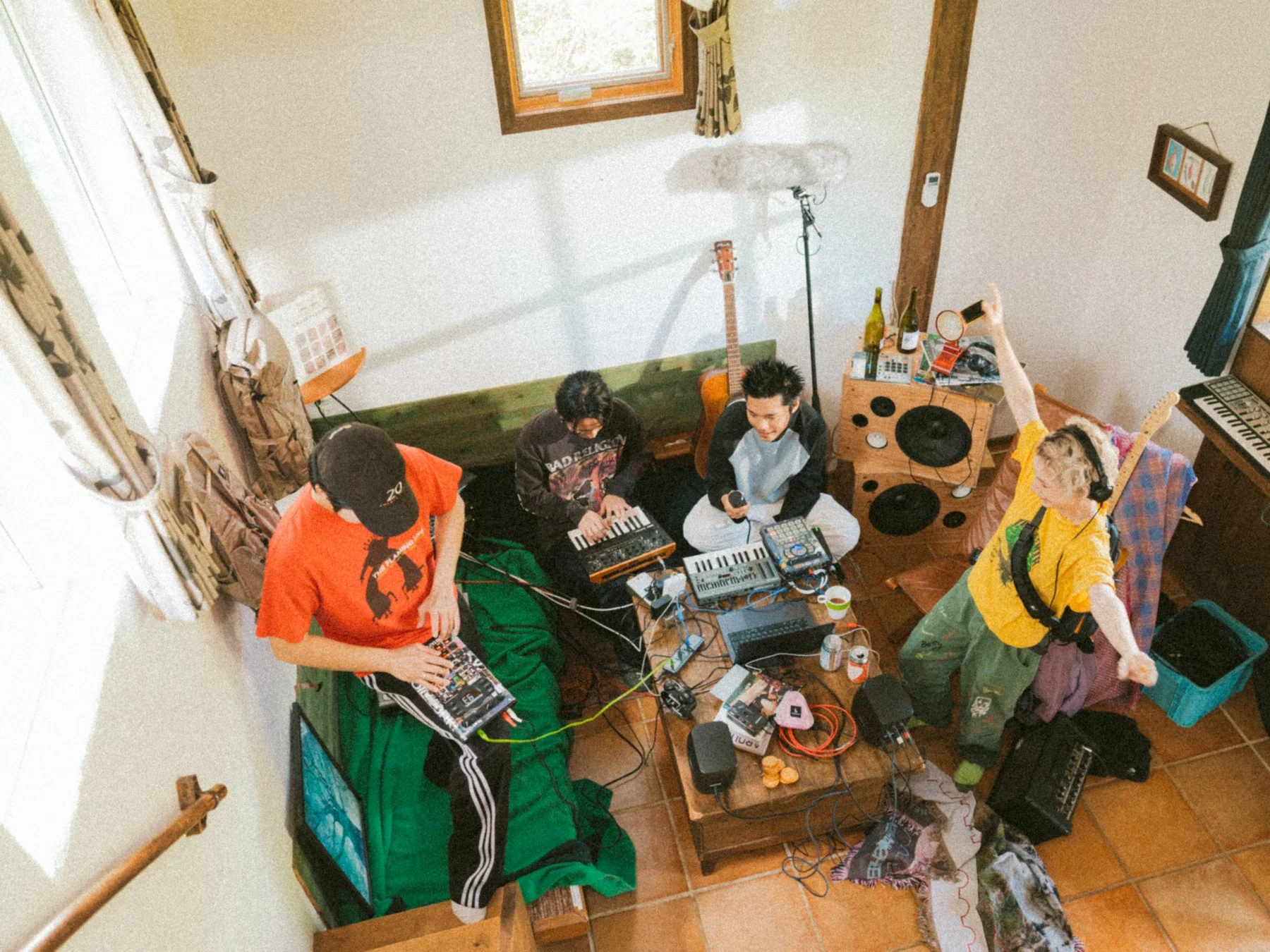 自宅のような空間で音楽制作や演奏を楽しむ男性たち