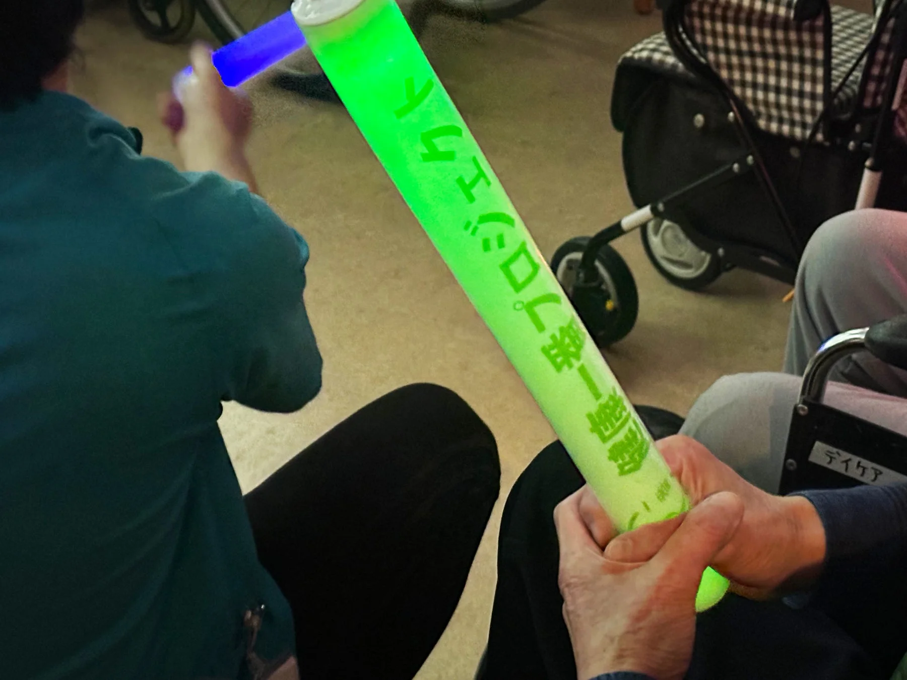 光る棒を持って楽しむデイケア参加者