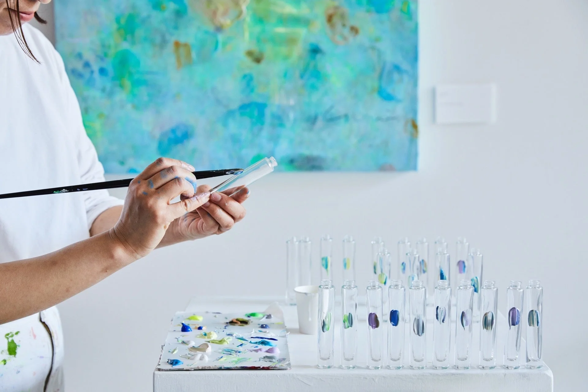 アーティストが試験管に絵の具を塗布