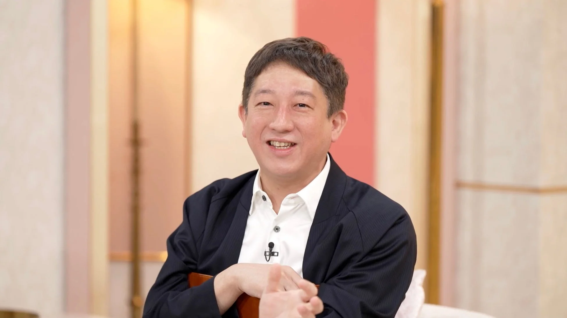 笑顔でカメラに視線を向けるアジア人男性