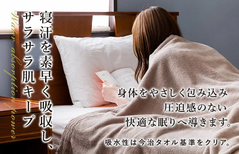 寝汗を素早く吸収し、肌をサラサラに保つタオルケットの広告画像です。女性がベッドで読書をしており、身体を優しく包み込み、圧迫感なく快適な眠りへ導くことを訴求しています。吸水性は今治タオル基準をクリア。