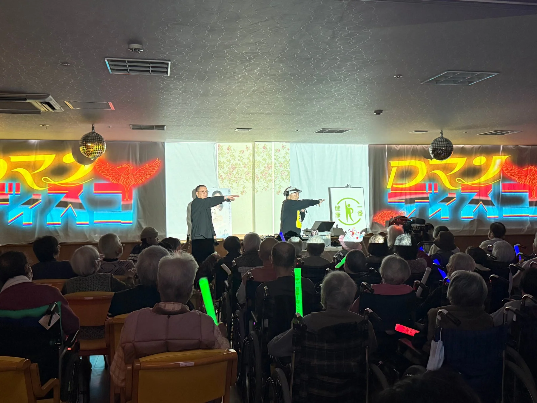 ペンライトを手に体操やダンスを楽しむ高齢者