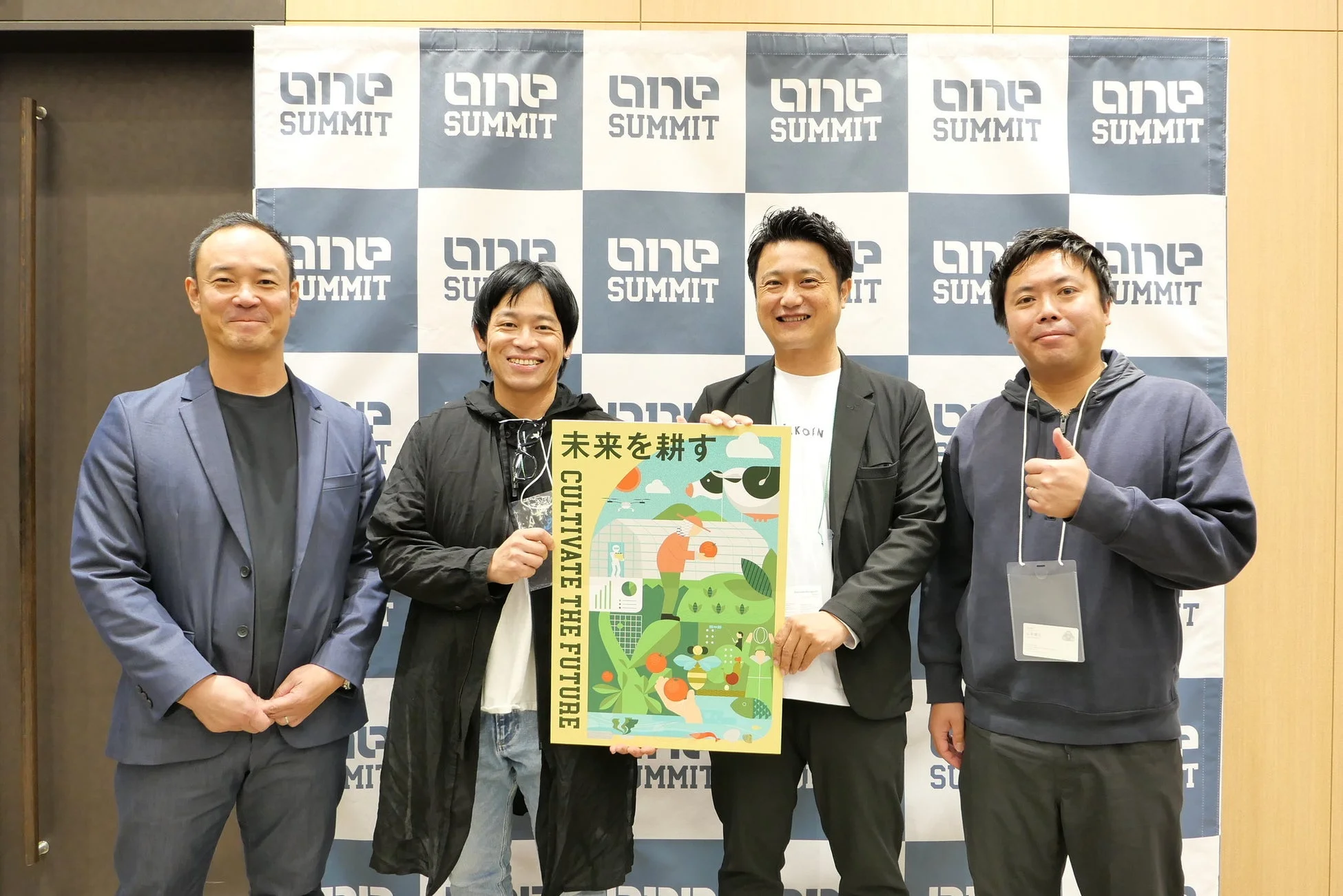 笑顔でポスターを囲む男性グループ