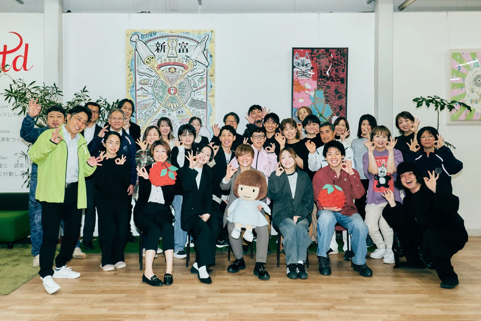 オフィスで笑顔でポーズをとる社員の集合写真