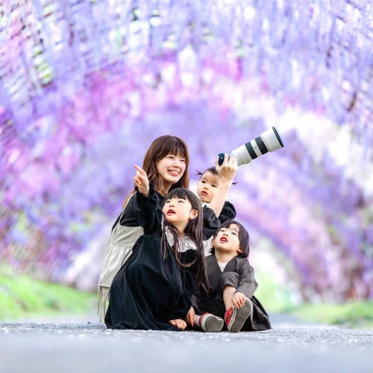 藤の花の下で子供たちとカメラを構えるmarii