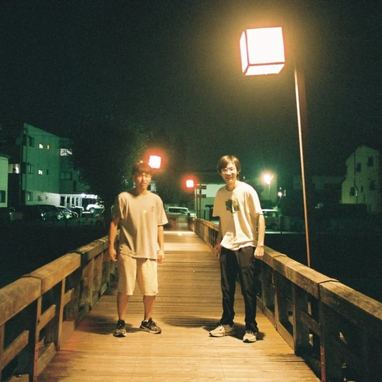 夜の橋に立つ二人の男性