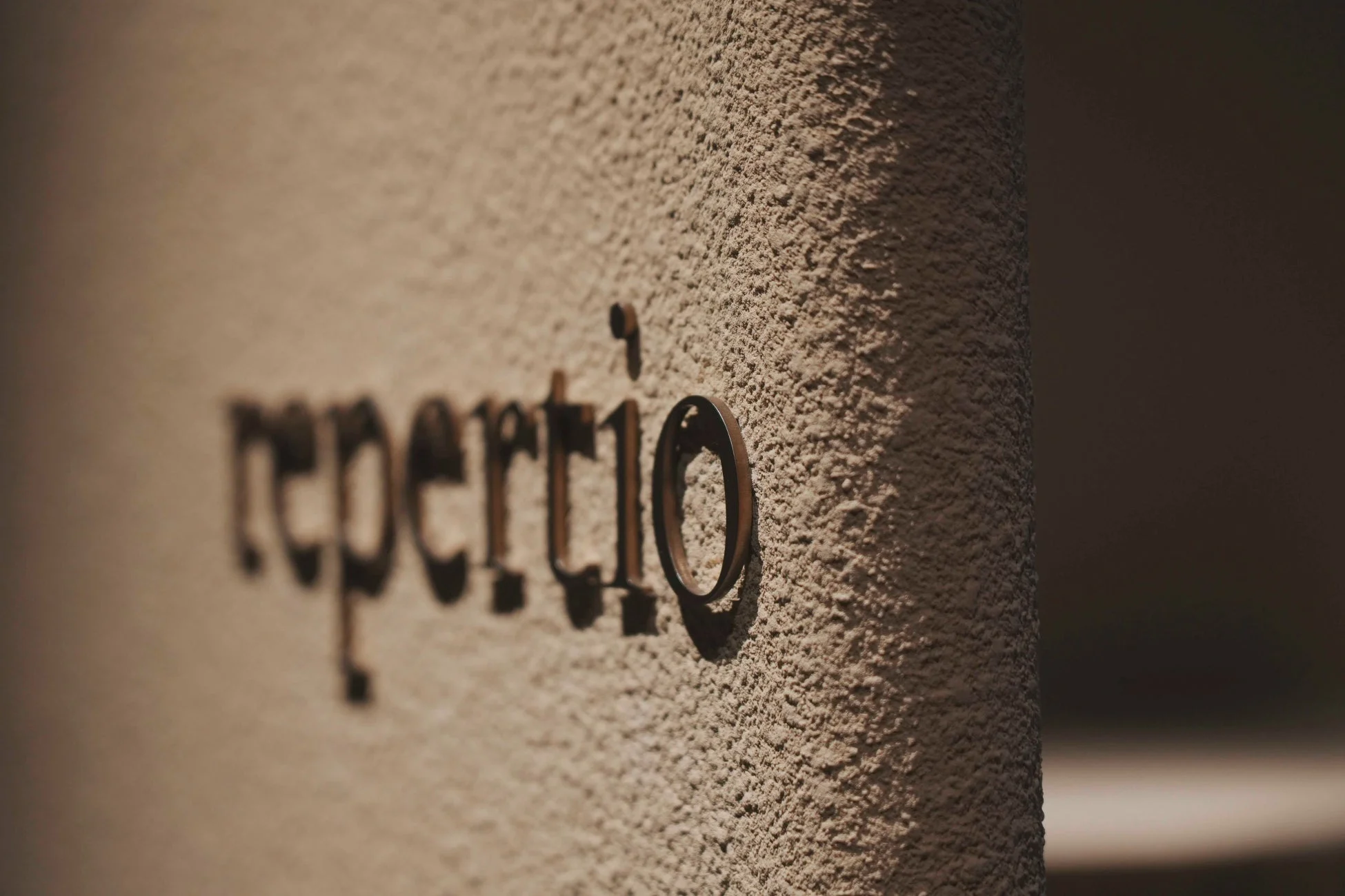 repertioのロゴと壁のテクスチャ