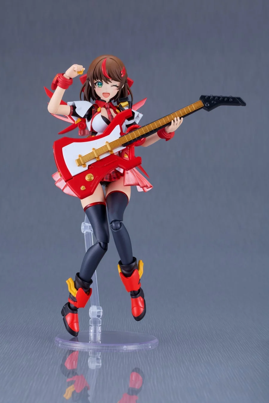 赤いエレキギターを弾く、赤と白のアイドル衣装を着たアニメ風の美少女フィギュアです。