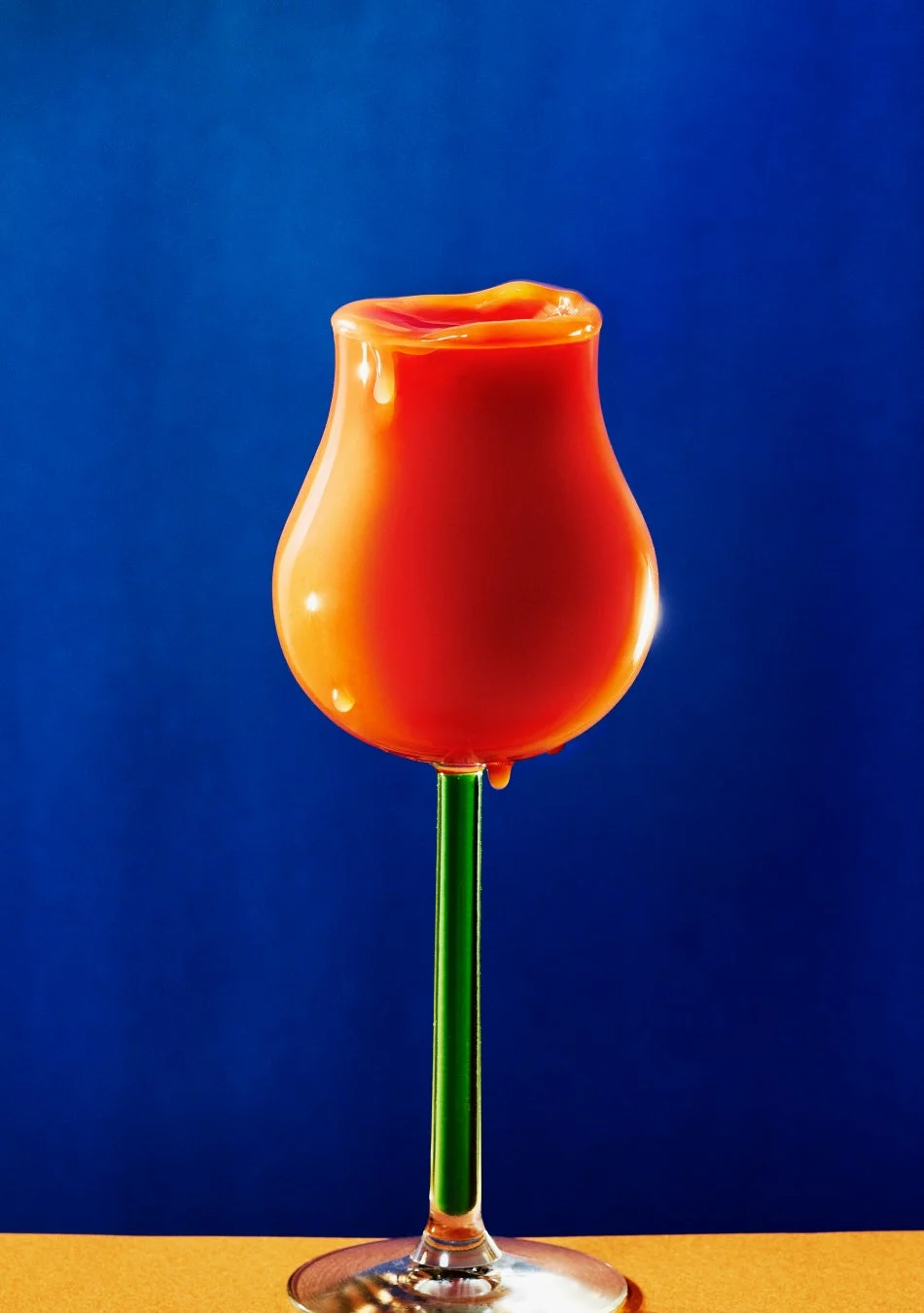 グラスから滴るオレンジ色の液体