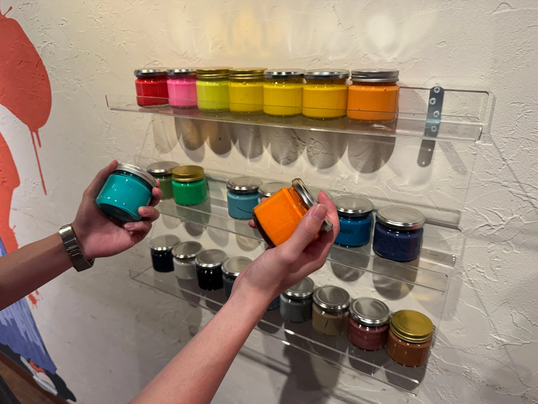 様々な色の絵の具が並んだ棚