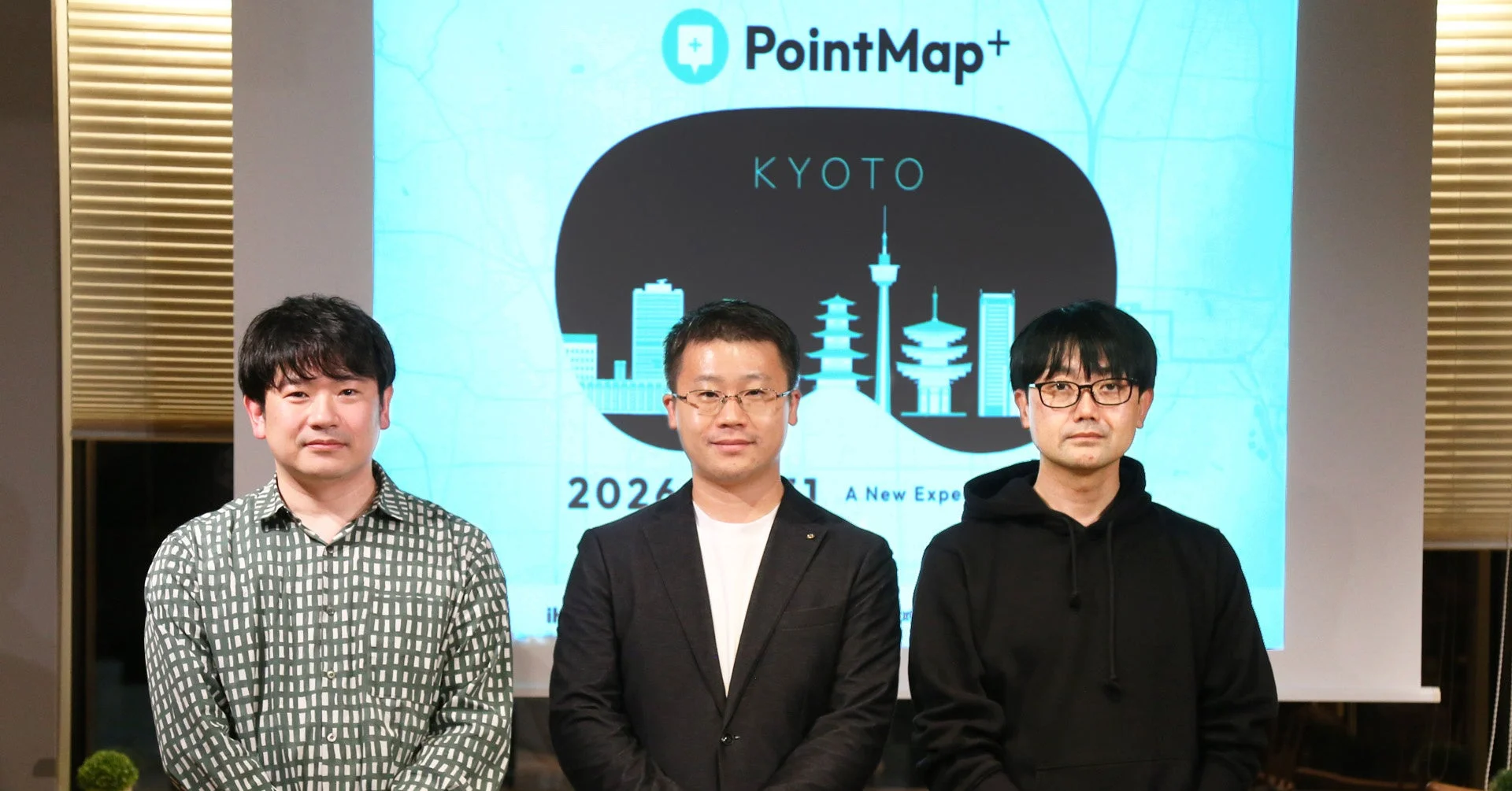「PointMap+ KYOTO」のロゴとテキストが表示されたスクリーンを背景に、3人の男性が並んで立っている