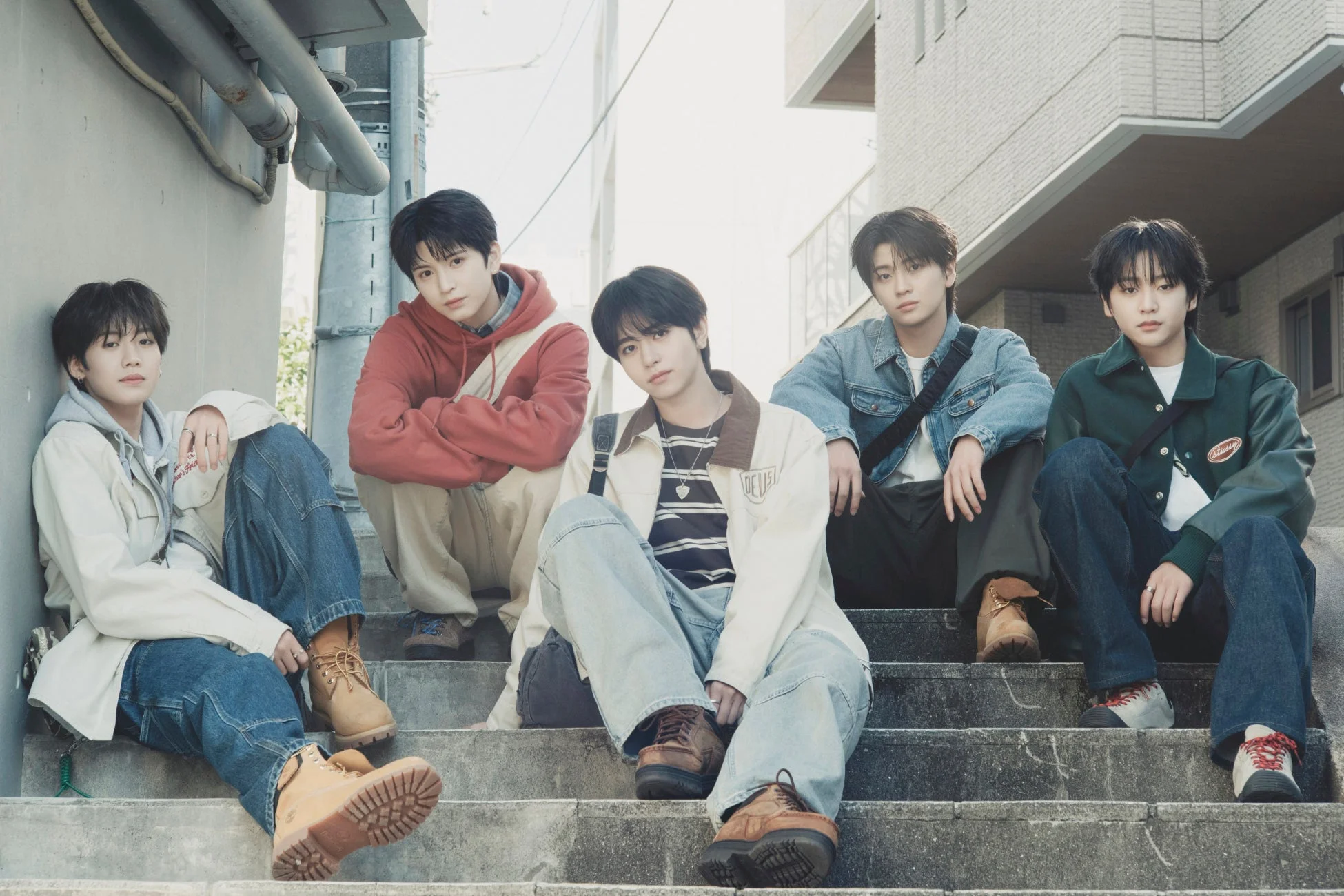 屋外のコンクリートの階段に座るVIBYのメンバー
