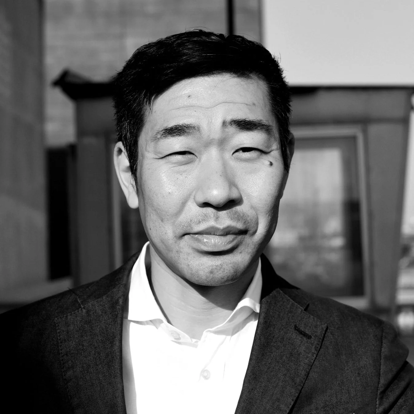 正面を向いたアジア人男性のモノクロポートレート。