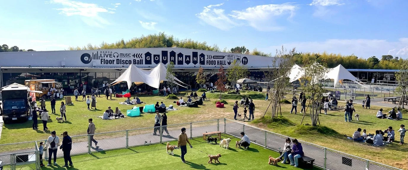 ドッグランで遊ぶ犬と人々が集まる屋外広場